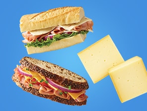 Fresh lunch meat sandwiches next to cheese wedges.