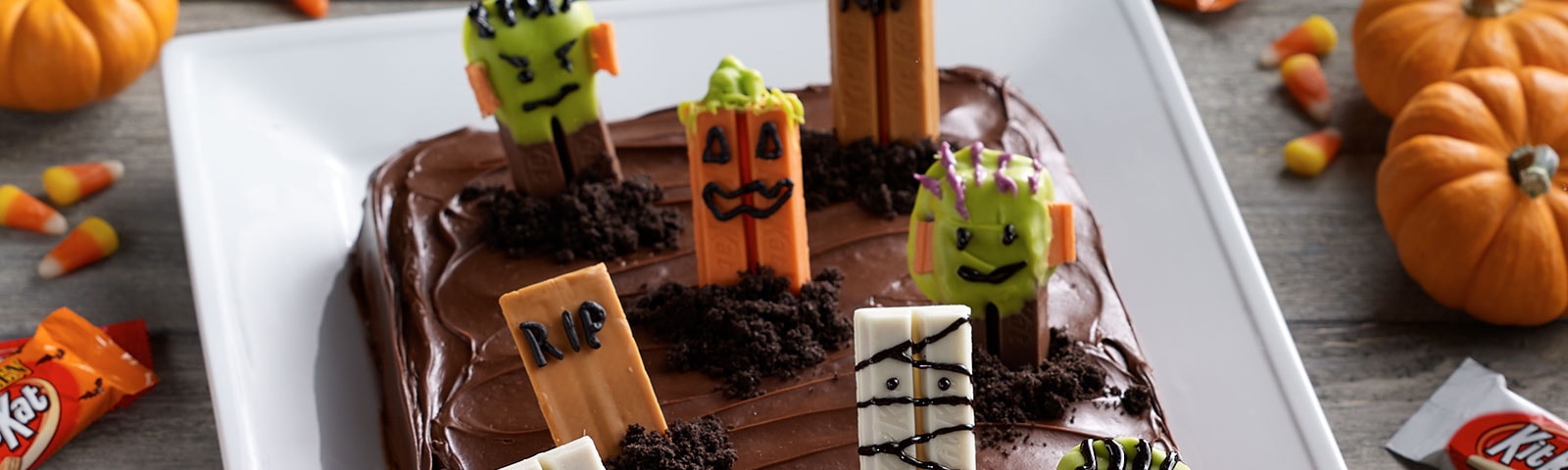 Chocolate cake with Halloween-themed Kit Kat bars placed on top to resemble a spooky graveyard Chocolate cake with Halloween-themed Kit Kat bars placed on top to resemble a spooky graveyard